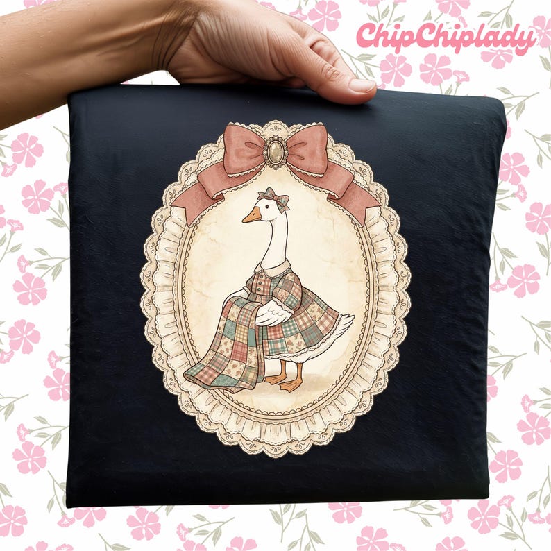 May include: A black square pillow featuring a whimsical illustration of a goose in a plaid dress, framed by a decorative oval with a pink bow. The pillow is held by a hand, with the text "ChipChipLady" in the upper right corner.
