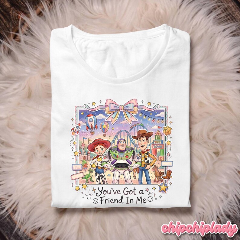 Peut inclure: T-shirt blanc avec un graphisme color&eacute; des personnages de Toy Story. Le design comprend Woody, Buzz l'&Eacute;clair et Jessie, avec le texte "You've Got a Friend In Me".