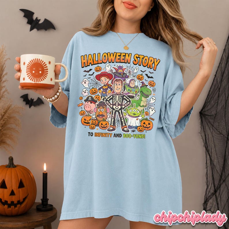May include: Light blue t-shirt with a Halloween-themed graphic. The design features characters from a popular animated movie dressed in Halloween costumes, with the text "HALLOWEEN STORY" and "TO INFINITY AND BOO-YOND!"