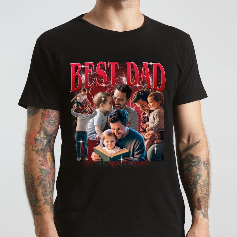 Pu&ograve; includere: T-shirt nero con una grafica di un padre con i suoi figli, con la scritta "BEST DAD" in rosso. L'immagine mostra un padre che legge al suo bambino e altri padri con i loro figli. La maglietta &egrave; girocollo.