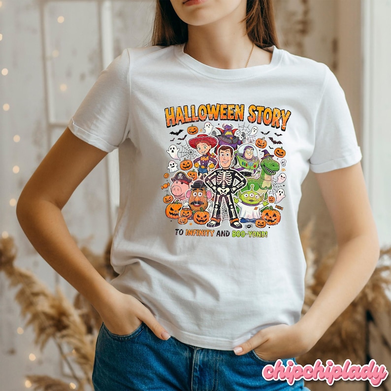 May include: White t-shirt with a colorful Halloween-themed graphic. The design features cartoon characters, pumpkins, bats, and the text "HALLOWEEN STORY" and "TO INFINITY AND BOO-YOND!"