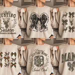 Op de afbeelding: Zes verschillende beige sweatshirts met verschillende jachtmotieven. De ontwerpen omvatten een hert met de tekst "Hello Hunting Season Goodbye Husband", een boog met de tekst "Dedicated Hunting Season", een boog met een hert, een boog met de tekst "Deserted Hunters' Wives Social Club", een boog met de tekst "Mama" en een boog met de tekst "Hello Hunting Season".