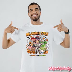 May include: White t-shirt with a colorful Halloween-themed graphic. The design features cartoon characters, pumpkins, bats, and the text "HALLOWEEN STORY" and "TO INFINITY AND BOO-YOND!"