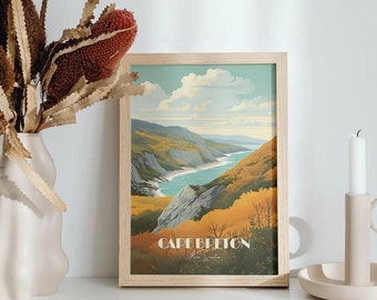 Op de afbeelding: Een ingelijste print van een landschapsscène met een waterpartij en heuvels op de achtergrond. De print is getiteld "Cape Breton". De print wordt weergegeven op een wit oppervlak met een vaas met gedroogde bloemen en een kandelaar.