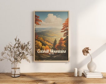 Puede incluir: Un póster de viaje de estilo vintage que presenta una vista panorámica de las montañas Catskill en Nueva York. El póster tiene un marco marrón y presenta un paisaje de follaje otoñal con un cielo azul y nubes blancas. El texto "Catskill Mountains New York" está impreso en blanco en el póster.
