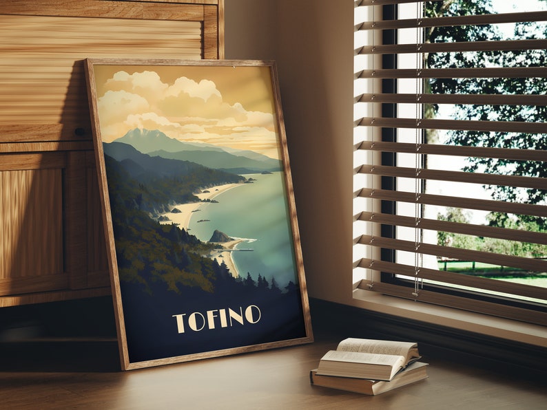 K&ouml;nnte beinhalten: Ein gerahmtes Poster mit einer Illustration im Vintage-Stil einer K&uuml;stenlandschaft. Das Poster zeigt eine Bergkette, einen Strand und eine Wasserfl&auml;che. Der Text "TOFINO" ist unten auf dem Poster in Wei&szlig; gedruckt.