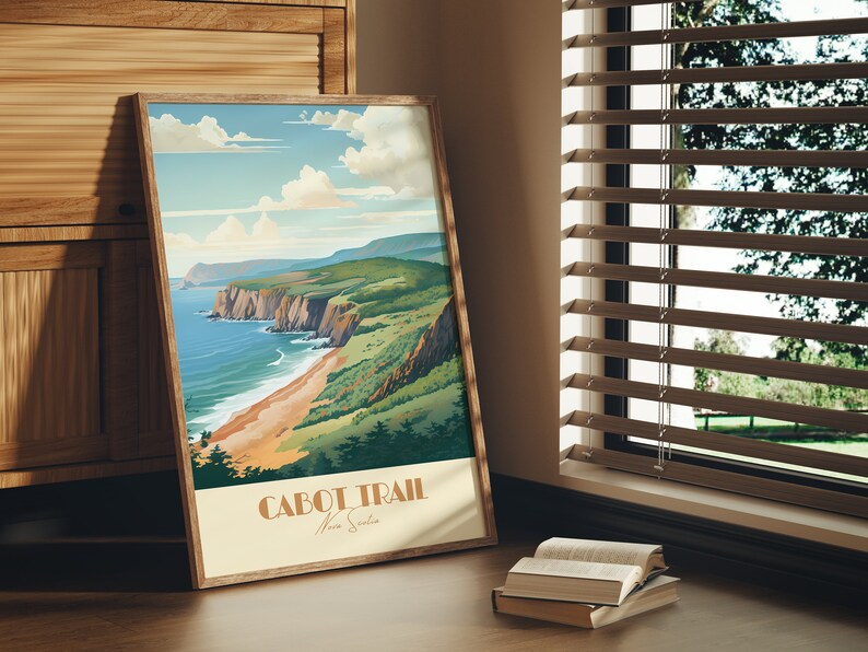 May include: A framed poster with a vintage travel illustration of a coastal landscape. The poster features a scenic view of a rocky coastline with a sandy beach and turquoise water. The text "CABOT TRAIL Nova Scotia" is printed at the bottom of the poster.