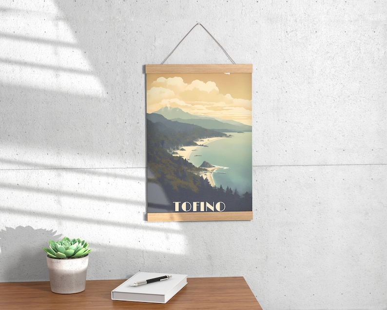 K&ouml;nnte beinhalten: Ein Vintage-Poster mit einer malerischen Aussicht auf eine K&uuml;ste mit Bergen im Hintergrund. Das Poster hat einen Holzrahmen und den Text "TOFINO" unten.