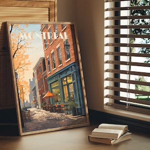 Könnte beinhalten: Eine gerahmte Illustration einer Straßenszene in Montreal, Quebec, Kanada. Die Illustration zeigt ein Backsteingebäude mit einem Ladenlokal, ein Café mit Tischen und Stühlen und einen Baum mit orangefarbenen Blättern. Der Text "Montreal" ist in weißen Buchstaben auf rotem Hintergrund geschrieben.