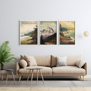 K&ouml;nnte beinhalten: Drei gerahmte Vintage-Reiseposter mit malerischen Landschaften. Das linke Poster zeigt eine Strandszene mit dem Text "East Sooke Regional Park". Das mittlere Poster zeigt eine Bergszene mit dem Text "Vancouver Island". Das rechte Poster zeigt eine Strandszene mit dem Text "Salt Spring Island".
