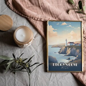 K&ouml;nnte beinhalten: Ein gerahmter Druck eines Leuchtturms auf einer Klippe mit Blick auf das Meer. Der Druck ist in einem goldenen Rahmen und hat den Text "Peggy's Cove Nova Scotia" unten.