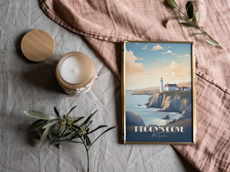 K&ouml;nnte beinhalten: Ein gerahmter Druck eines Leuchtturms auf einer Klippe mit Blick auf das Meer. Der Druck ist in einem goldenen Rahmen und hat den Text "Peggy's Cove Nova Scotia" unten.