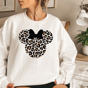 May include: White sweatshirt with a black and brown leopard print Mickey Mouse head design.