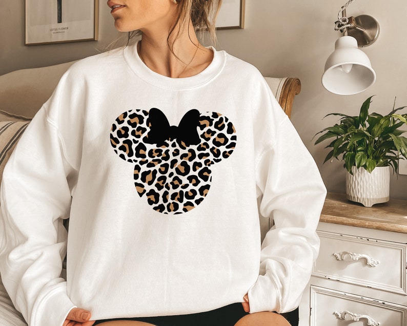 May include: White sweatshirt with a black and brown leopard print Mickey Mouse head design.