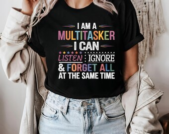 May include: A black t-shirt with a colorful graphic that says "I am a multitasker I can listen: ignore & forget all at the same time".