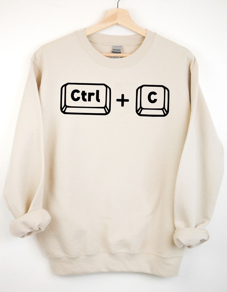 May include: A beige sweatshirt with a black graphic of the computer keys "Ctrl" and "C" printed on the front.