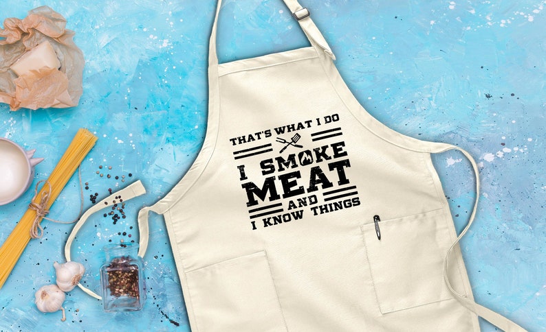 May include: White cotton apron with a black print that says "That's what I do I smoke meat and I know things".