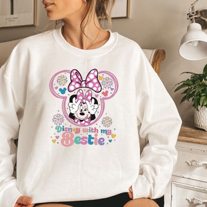 May include: White sweatshirt with a pink Minnie Mouse graphic and the text "Disney with my Bestie" in rainbow colors.