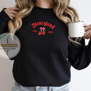 May include: Black sweatshirt with the text "Disneyland Est. 1955" and a red cherry graphic.