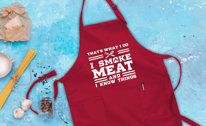 May include: Red apron with a white graphic that says "That's what I do I smoke meat and I know things".