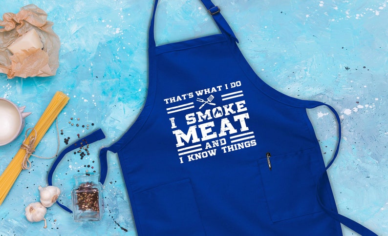 May include: Blue apron with a white graphic that says "That's what I do I smoke meat and I know things".