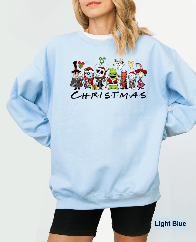 Pu&ograve; includere: Felpa blu chiaro con una stampa grafica di vari personaggi dei cartoni animati di film di Natale popolari. I personaggi includono Jack Skellington, Oogie Boogie e il Grinch. Il testo "CHRISTMAS" &egrave; stampato sotto i personaggi.