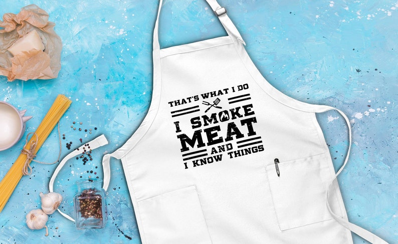May include: White apron with black text that reads "That's what I do I smoke meat and I know things". The text is in a distressed font and includes a grill and spatula graphic.