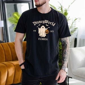 May include: Black t-shirt featuring a white ghost holding a pumpkin and the text "DisneyWorld est 1971 FLORIDA".