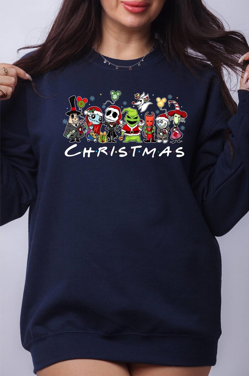 Pu&ograve; includere: Felpa blu navy con una stampa grafica di vari personaggi dei cartoni animati, tra cui Jack Skellington, il Grinch e Oogie Boogie. Il testo "CHRISTMAS" &egrave; stampato sotto i personaggi.
