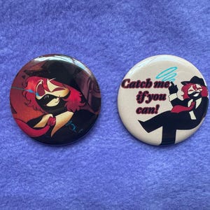 May include: Two round buttons with illustrations. One features a character with red hair and a mask, set against a dark background. The other button has a cartoon figure with the text "Catch me if you can!"