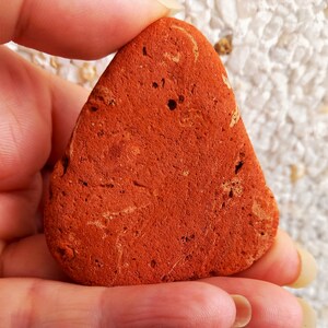 FRAGMENTO de CERÁMICA TRIANGULAR: fragmento hermoso de terracota antigua con líneas de tonalidades variadas, pulida y desgastada por el mar.