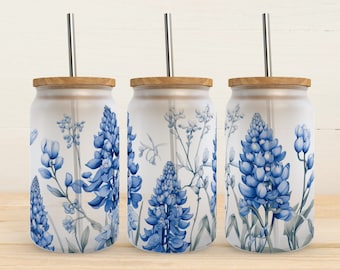 May include: Three clear glass tumblers with wooden lids and stainless steel straws. Each tumbler features a blue and white floral design with a bluebonnet pattern.