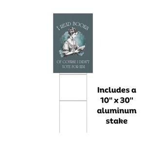 May include: A teal blue yard sign with a black and white illustration of a woman reading a book. The text on the sign reads "I Read Books Of Course I Didn't Vote For Him". The sign includes a 10" x 30" aluminum stake.