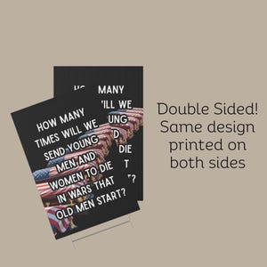 May include: Black yard sign with the text "HOW MANY TIMES WILL WE SEND YOUNG MEN AND WOMEN TO DIE IN WARS THAT OLD MEN START?" and an image of coffins draped with the American flag. The sign is double-sided.