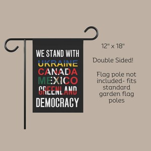 May include: A black garden flag with the text "We Stand With" and the names of countries: Ukraine, Canada, Mexico, Greenland, and Democracy. The flag is 12 inches by 18 inches and is double-sided.