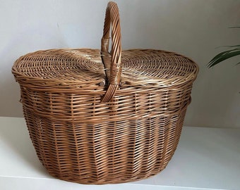 May include: A brown wicker picnic basket with a hinged lid and a woven handle.