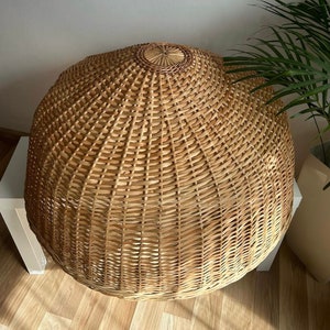 May include: A large, round, natural woven wicker lampshade with a light brown color.