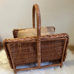 May include: A brown wicker log holder with a handle. The holder is empty and has a woven design.