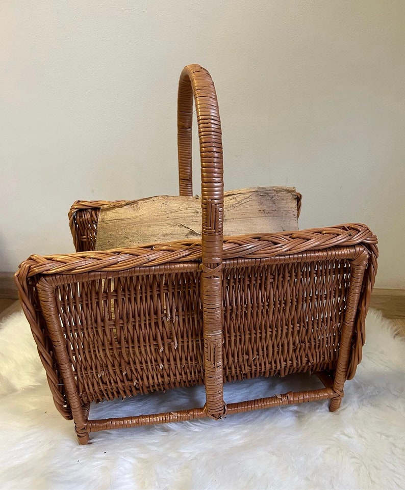 May include: A brown wicker log holder with a handle. The holder is empty and has a woven design.