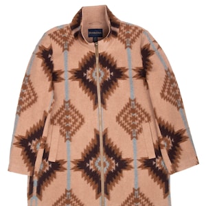 May include: A tan zip-up jacket featuring a geometric pattern in dark brown and light blue. The jacket has a high collar, a full-length gold-tone zipper, and two side pockets. A Pendleton brand label is visible on the inside of the collar.