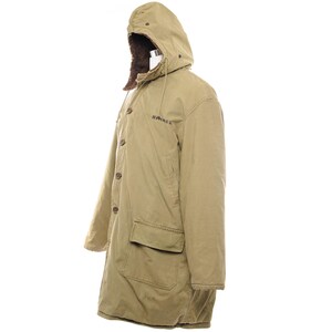 May include: A tan, hooded coat with a button-up front and two front pockets. The hood is lined with brown faux fur. The word "HIMMEL" is embroidered on the chest. The coat is designed for cold weather.
