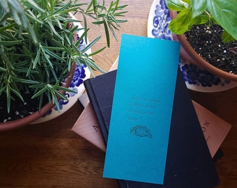 Impressão tipográfica com citação de Cícero, em tons de azul-petróleo e dourado, para biblioteca de jardim.