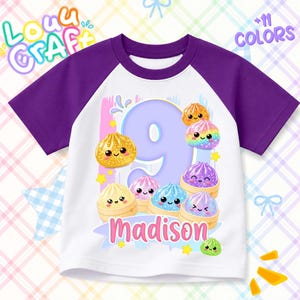 May include: A white t-shirt with purple raglan sleeves featuring a large light purple number 9, the name Madison in pink, and several colorful, smiling dumpling illustrations. The design includes small yellow stars and blue accents.