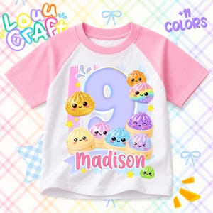 May include: A white and pink raglan t-shirt featuring a large purple number nine surrounded by colorful, smiling dumpling illustrations. The name Madison is printed in pink below the number. The text Louu Craft and +11 Colors are visible.