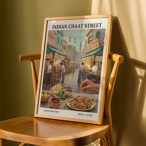 May include: A framed print showing an Indian street food market scene. The artwork features food stalls, people, and the text "INDIAN CHAAT STREET". The print is displayed on a wooden chair.