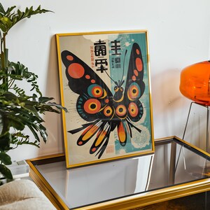 May include: A framed print of a colorful butterfly with black wings and red, yellow, and blue accents. The butterfly is surrounded by a blue and white background with Japanese text that reads "主頁" and "壽百年".
