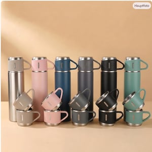 May include: A collection of six stainless steel vacuum insulated thermos bottles, each paired with a matching cup. The set includes colours in silver, light pink, navy blue, dark grey, black, and sage green, all featuring a sleek, cylindrical design.
