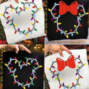 May include: Four decorative throw pillows, two white and two black, each featuring a Mickey Mouse head outline made of Christmas lights. Two pillows have a red bow. The lights are in various colors.