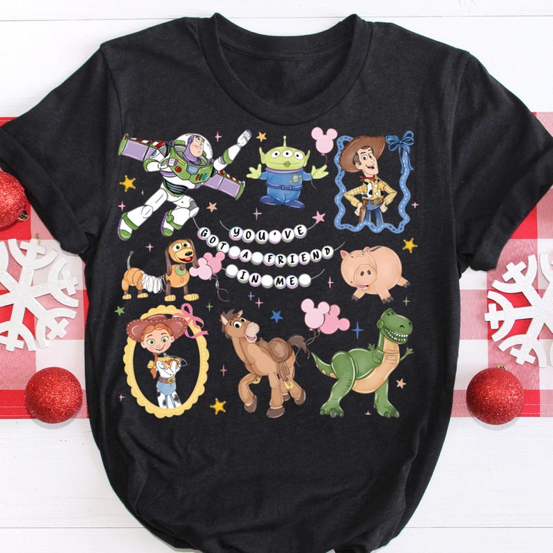 Puede incluir: Camiseta gris oscuro con personajes de dibujos animados coloridos de una popular pel&iacute;cula de animaci&oacute;n. La camiseta incluye a Buzz Lightyear, Woody y otros personajes, con la frase "You've Got a Friend in Me".