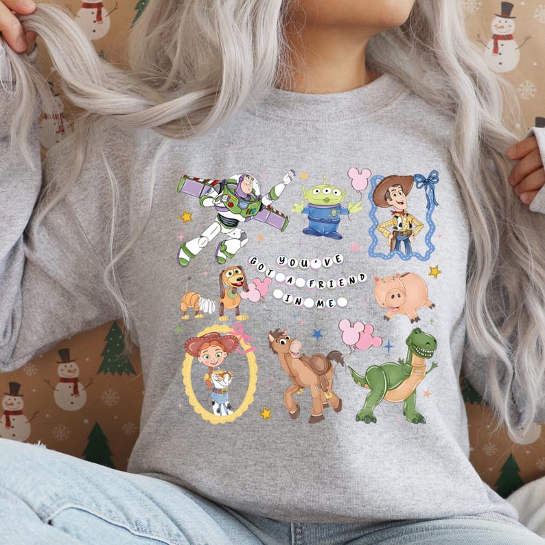 Puede incluir: Sudadera gris claro con personajes de Toy Story. El dise&ntilde;o incluye a Buzz Lightyear, Woody, Jessie y los peque&ntilde;os hombrecitos verdes, con la frase "You've Got a Friend in Me".